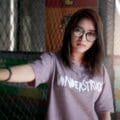 Portrait of a young woman wearing eyeglasses and a 'Wonderstruck' t-shirt posing indoors.