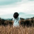 Young woman enjoying a serene moment in a wheat field during summer.