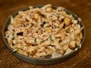Loaded fries dengan saus, paneer, dan taburan cabai untuk inspirasi menu kafe